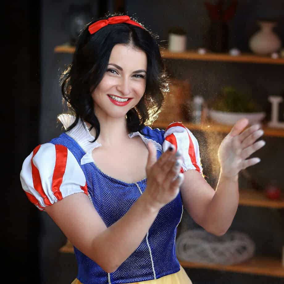 a girl in the image of snow white from the Disney cartoon is preparing an apple pie