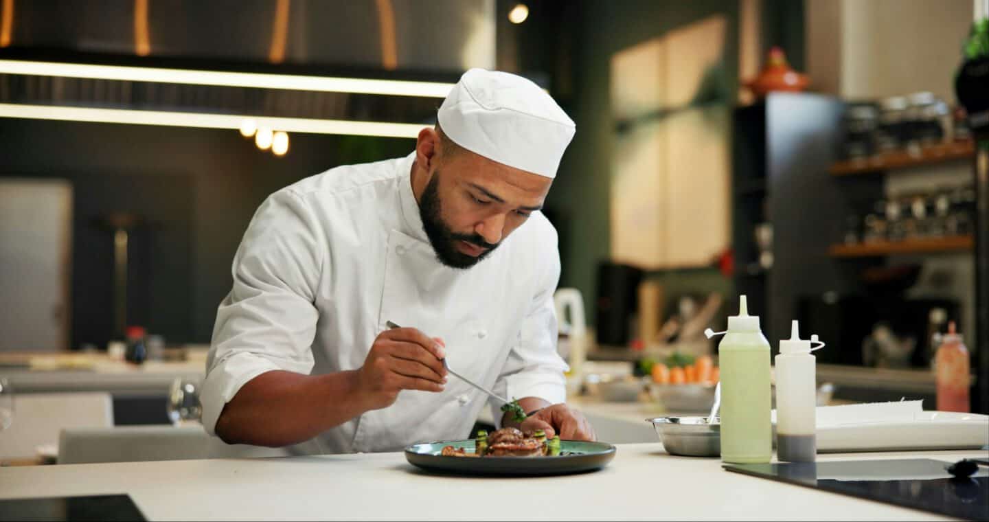 Man, chef and serious with food in kitchen at restaurant for fine dining, meal and creativity. Male